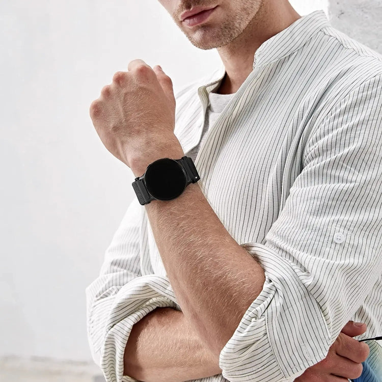Black nylon loop watch band worn on wrist with metal clasp