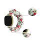 White floral cloth watch band with red flowers and green leaves; smartwatch shown.