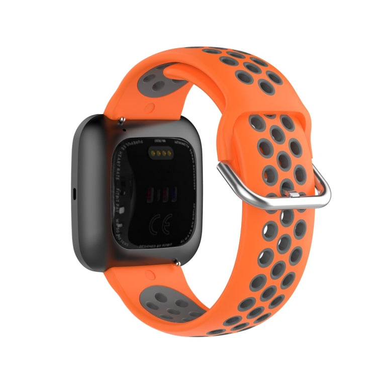 Two-color sport watch band in orange and gray, clasp and perforated underside view