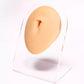 Flesh-tone silicone facial feature insert on clear stand with central opening