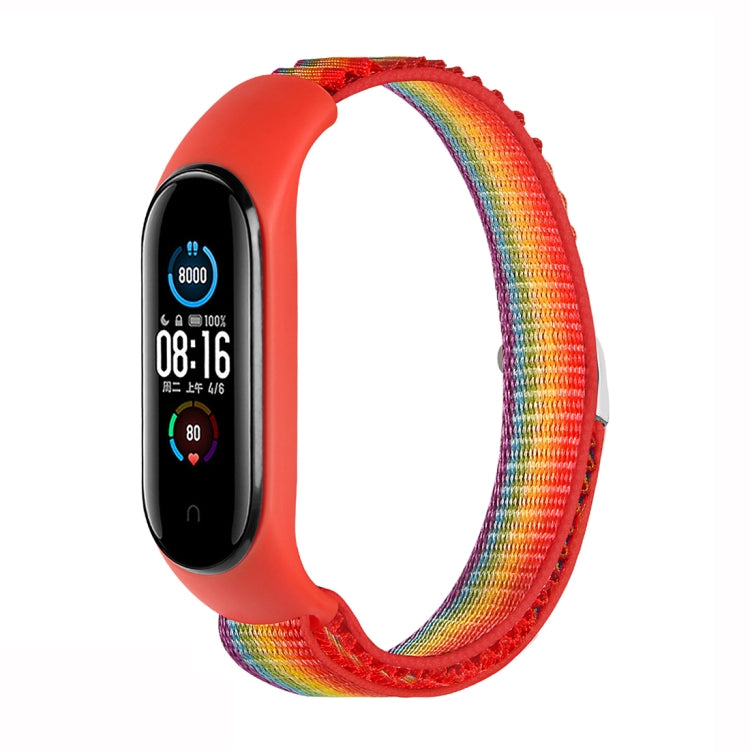 Rainbow nylon loop watch band with orange fitness tracker attached, adjustable strap.