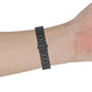 Black three-bead metal watch strap on wrist