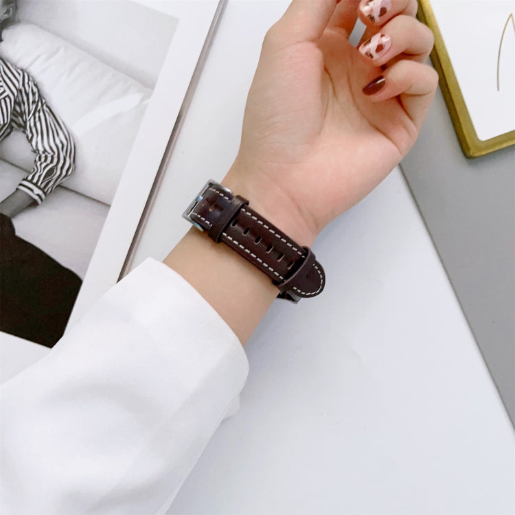 Brown grooved leather watch band close-up with buckle and stitched holes
