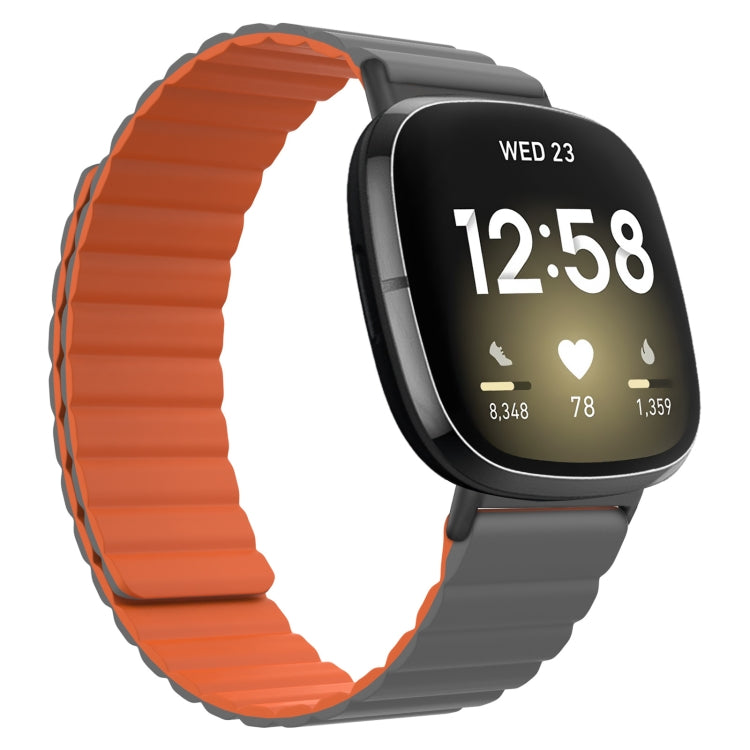 Orange silicone magnetic watch band with gray clasp, shown on a smartwatch with black screen