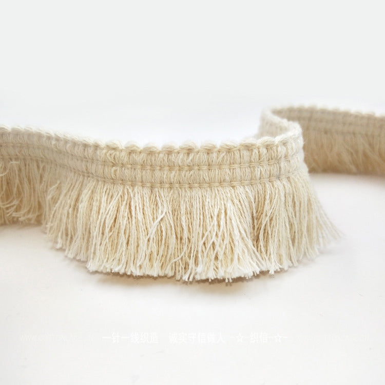 Beige cotton tassel lace trim ribbon with fringed ends along a braided band