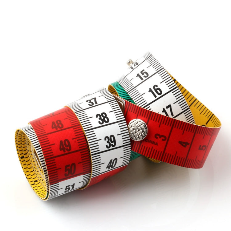Measuring tape roll and overlapping scales with red, yellow, and white rulers