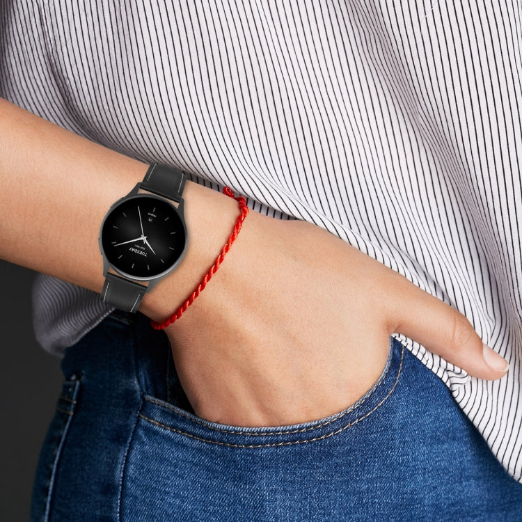 Genuine leather watch band in dark gray on wrist with metal buckle and strap holes