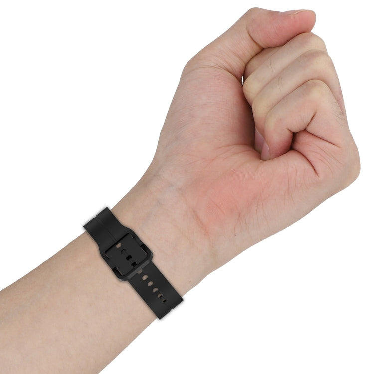 Silicone watch band on wrist with prong buckle and adjustment holes, black
