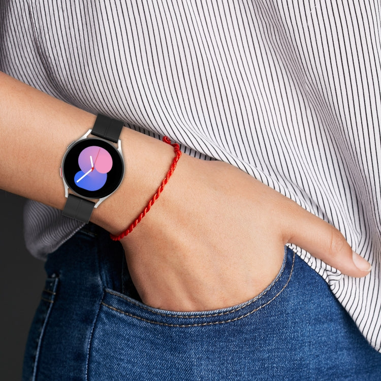 Silicone watch band on wrist with prong buckle and adjustment holes, black