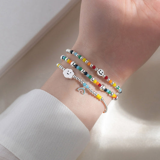 Sterling silver beaded bracelet set with small cloud charm and rainbow detail on wrist