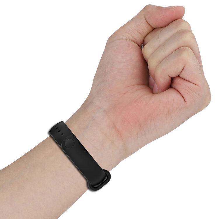 Black silicone smartwatch strap worn on hand with pin-and-loop style clasp