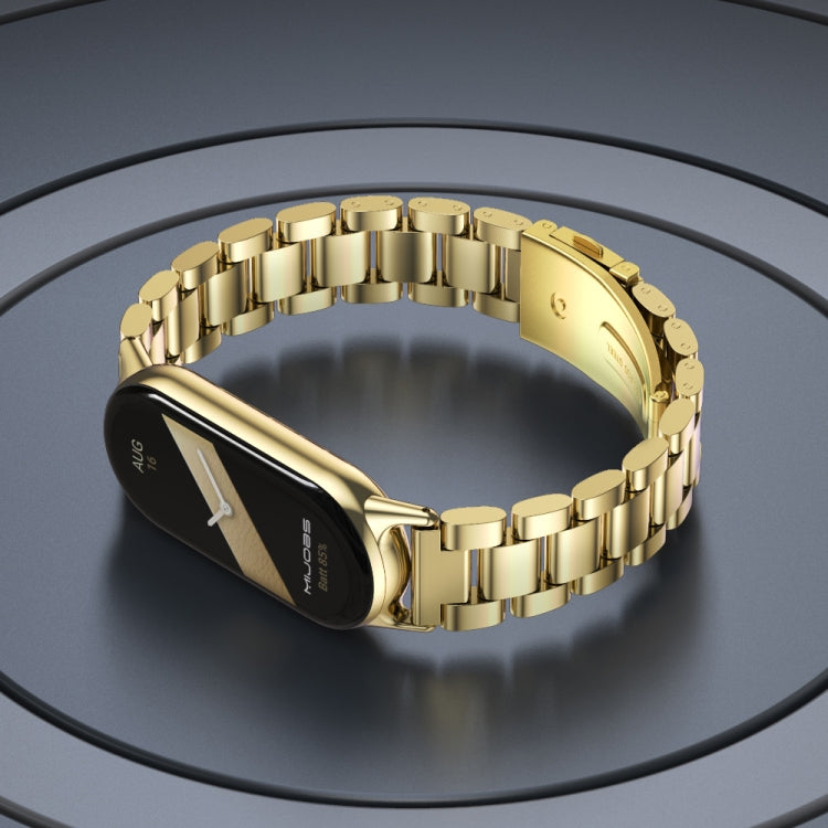 Light gold three-bead stainless steel watch band with clasp and round link accents, on watch
