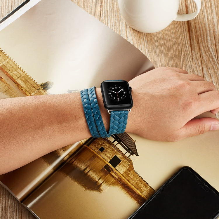 Blue braided leather watch band with embossed crown pattern worn on wrist
