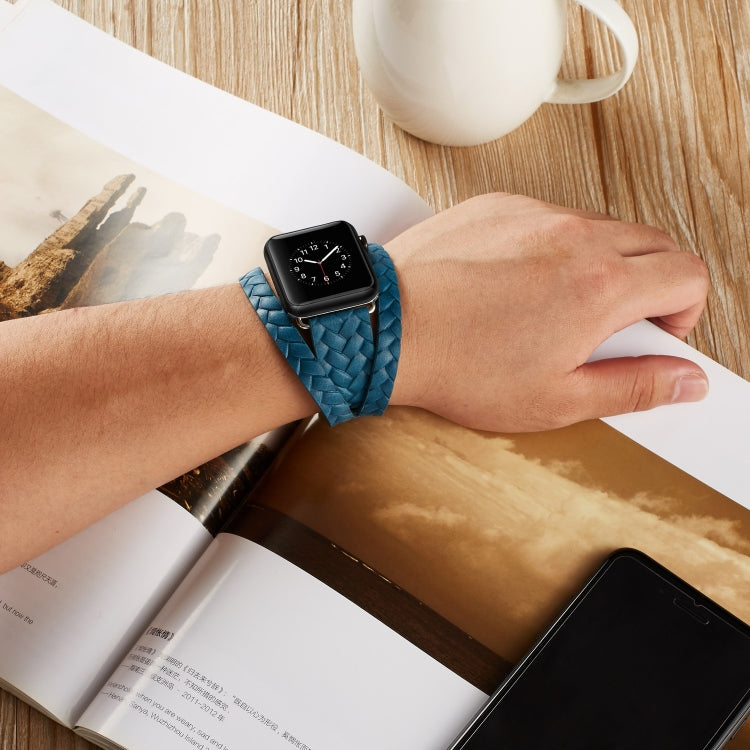 Blue embossed crown leather watch band worn on wrist with braided woven strap