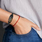 Black link replacement watch band worn on wrist with fitness tracker display