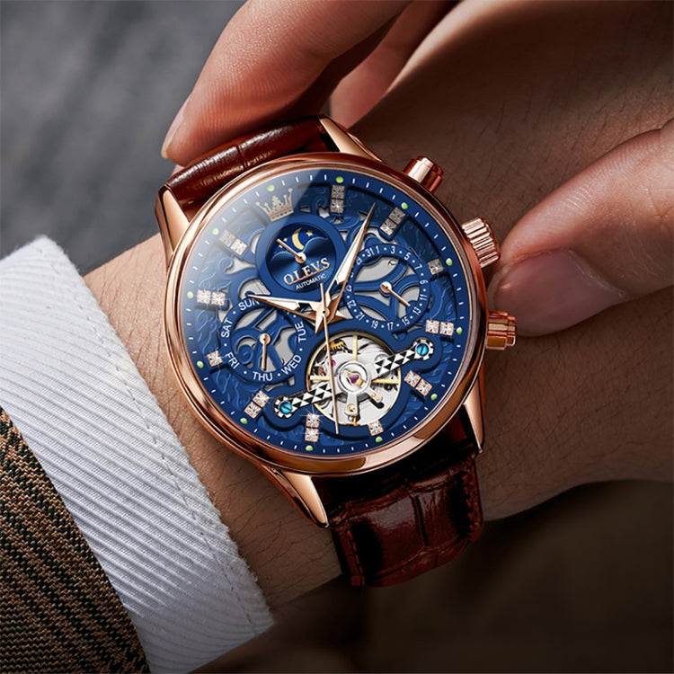 Blue dial mechanical watch on wrist with brown leather strap and rose-gold case