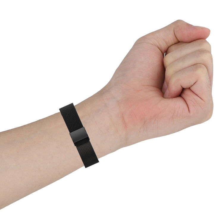 Black mesh watch strap worn on wrist with buckle on outer side