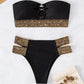 Black bikini set with gold chain-trimmed bandeau top and high-waist bottoms, flat lay
