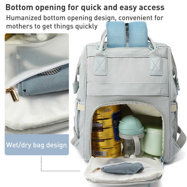 Light blue mommy backpack open bottom compartment with bottles in separated pockets.