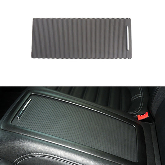 Dark gray ribbed armrest storage box insert panel with side handle slot