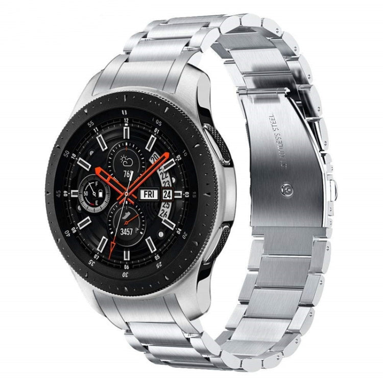 Silver stainless steel watch band with curved links and flat buckle, worn on watch.