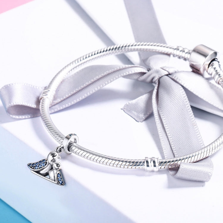 Sterling silver bracelet with blue bird charm and ribbon-tied clasp detail