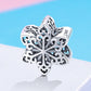 Sterling silver snowflake charm bead with filigree cutouts, side view