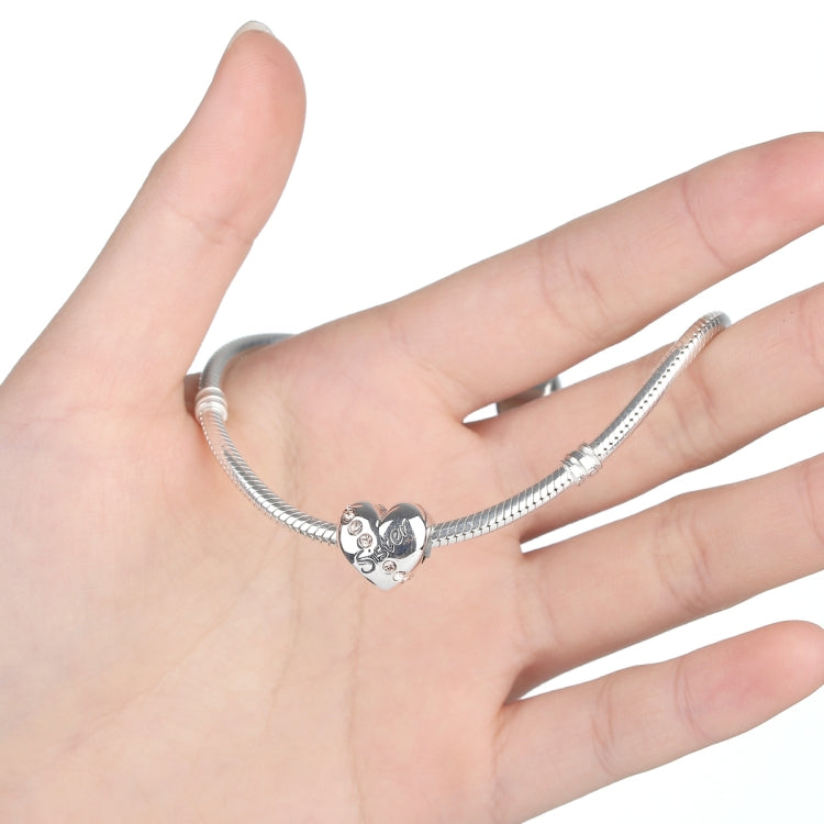 Silver link bracelet on hand with heart charm bead featuring 'Sister' and crystals