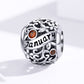 Sterling silver birthstone charm bead with January script and two orange crystals
