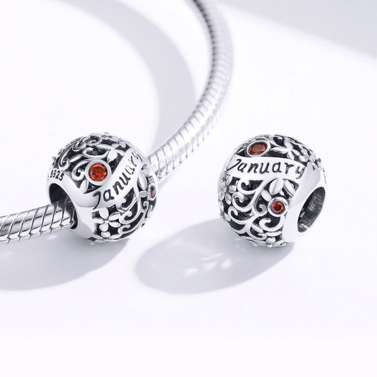 Sterling silver charm beads with January script and orange crystals on a snake bracelet