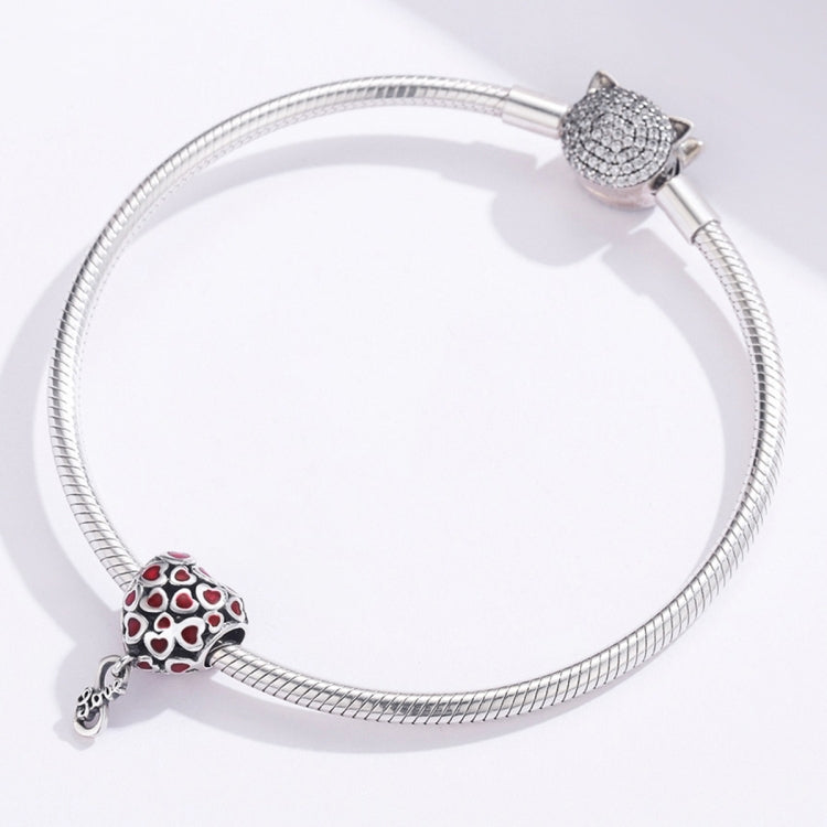 Silver charm bracelet with a red heart enamel bead charm and another cat-like charm