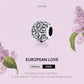 Oxidized sterling silver flower-pattern charm bead with carved scroll details