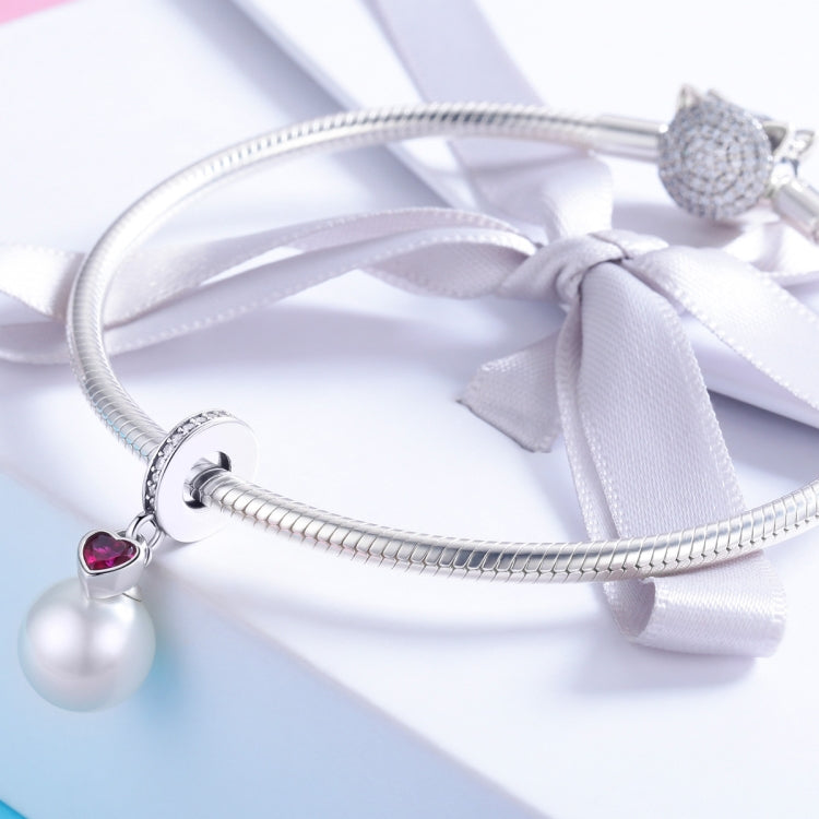 Silver bracelet charm with small red heart gem and white pearl bead