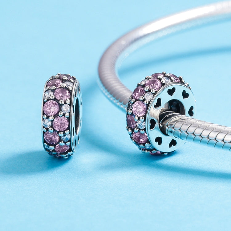 Sterling silver bracelet charm bead with pink stones and black enamel patterns, on bracelet