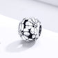 Sterling silver daisy charm bead with faceted petal embossing and dark oxidized accents