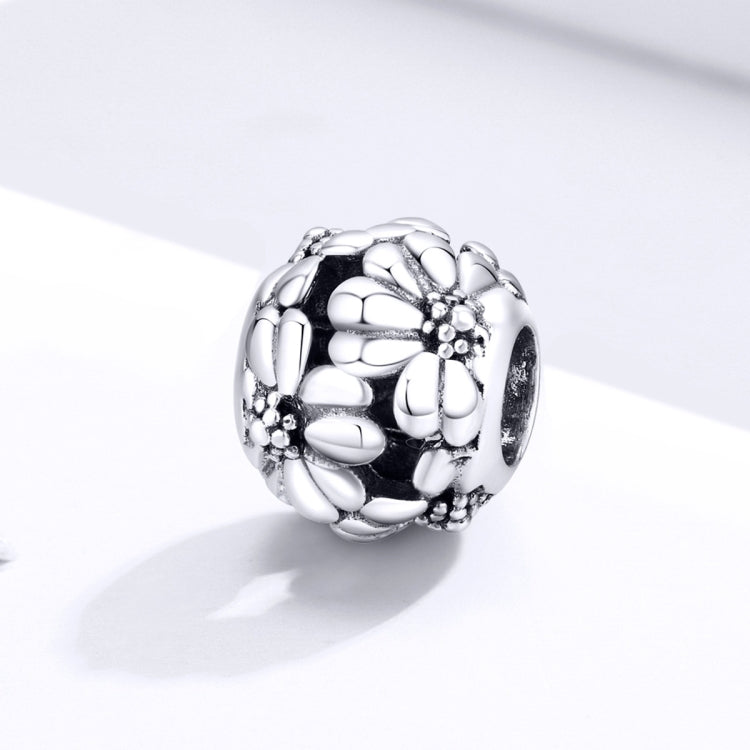 Sterling silver daisy charm bead with faceted petal embossing and dark oxidized accents