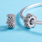 Pair of sterling silver daisy wreath bead charms with orange centers, side and front views