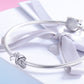 Sterling silver bow knot charm on a snake chain with a white ribbon accent