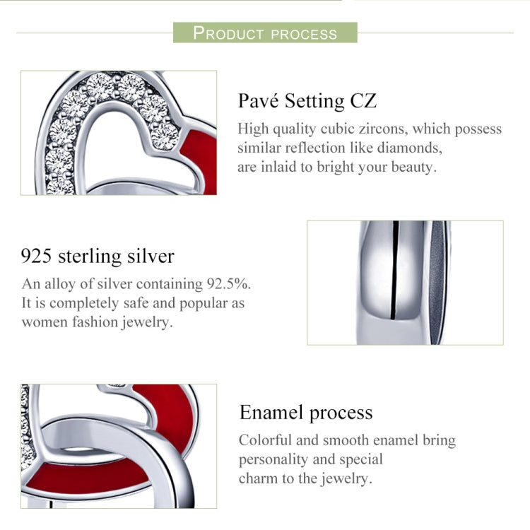 Close-up of sterling silver heart charm with red enamel and sparkling stone border