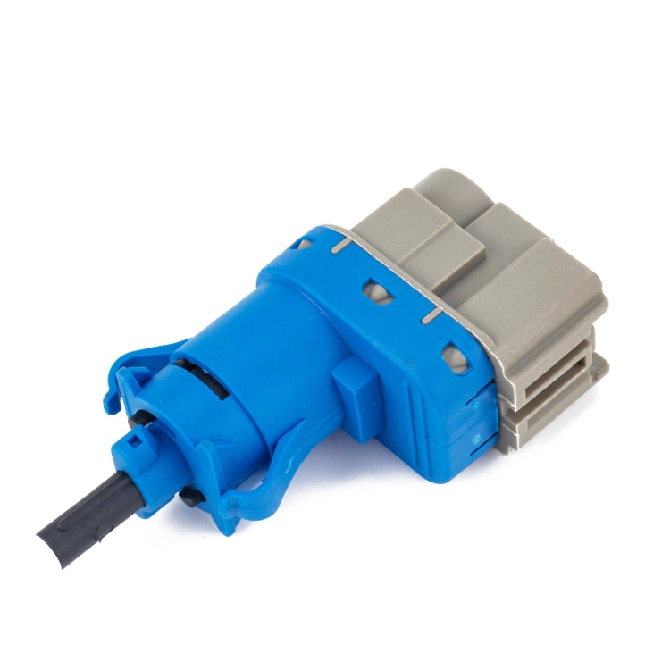 Brake light switch with blue actuator, gray housing, and mounting tabs