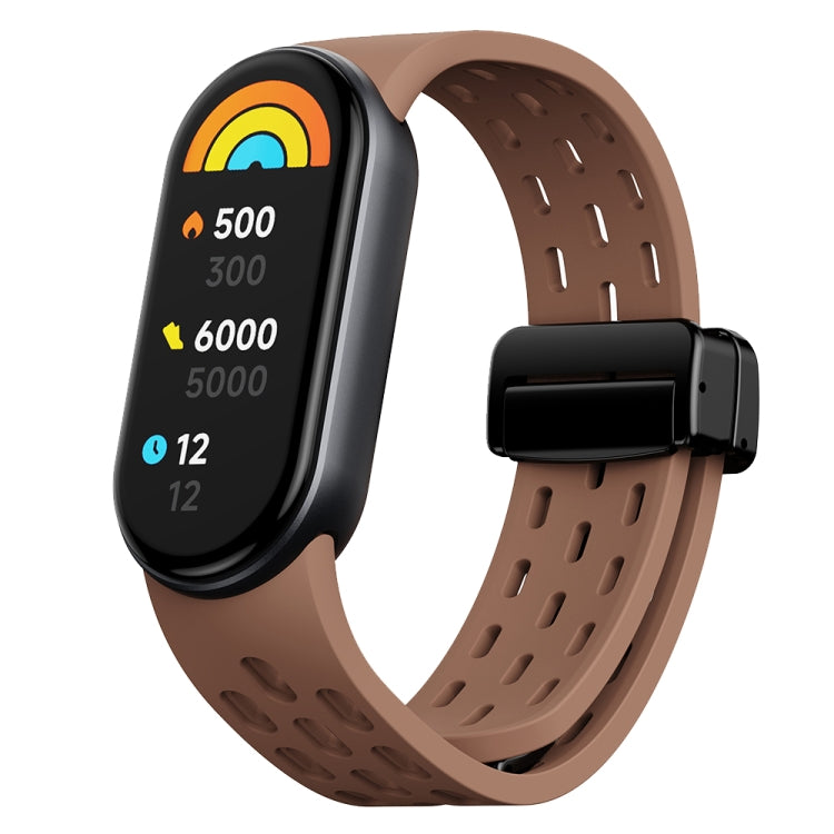 Brown perforated silicone watch band with black magnetic buckle and fitness tracker