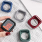 Silicone Apple Watch cases in navy, gray, red, and teal, shown beside a watch
