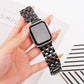 Black five-bead stainless steel band fitted to an Apple Watch, held in hand.