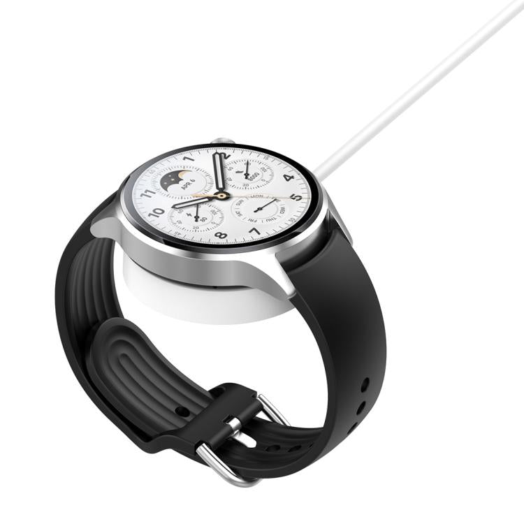xDfind magnetic charging pad beneath a silver smartwatch with a black strap