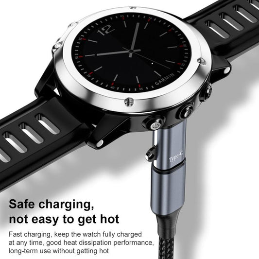 xDfind watch charging adapter connected to a silver-bezel smartwatch.