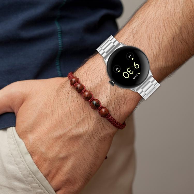 Silver metal watch band worn on a wrist