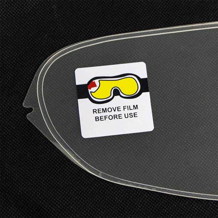 Anti-fog visor lens film applied on curved dark helmet shield, with “remove film before use” label