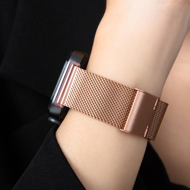 Rose gold Milanese watch band worn on a wrist.
