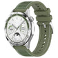 Green hybrid nylon and silicone watch band with stitched panels and adjustable holes, shown on a watch.