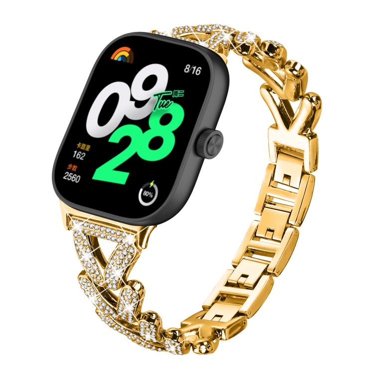 Gold metal smartwatch band with crystal-studded geometric links, shown attached to a watch